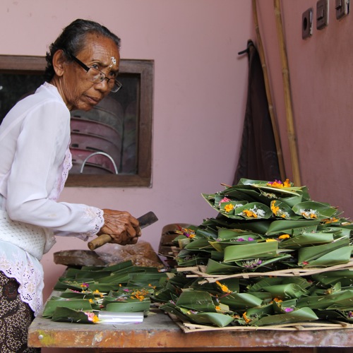 Een Balinese vrouw met offerbakjes