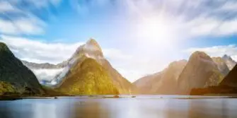 Uitzicht op Milford Sound met Mitre Peak en zonlicht boven de fjord in Nieuw-Zeeland
