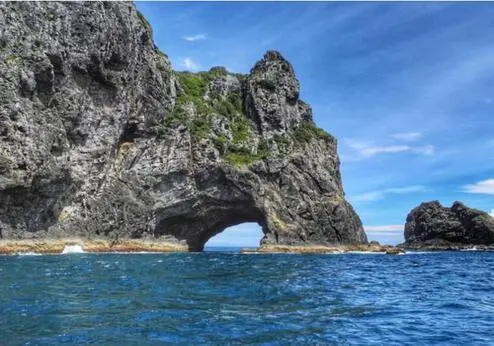 Rotsformatie met natuurlijke opening in zee bij Hole in the Rock bij Paihia in Nieuw-Zeeland