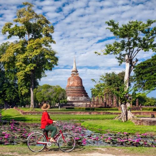 Fietsende vrouw door Sukhothai Historical Park