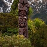 Een traditionele Pou Whenua-houten paal met Whakairo-houtsnijwerk uit de Māori-cultuur.