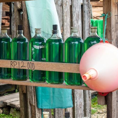 Glazen flessen gevuld met benzine langs de wegen in Indonesië