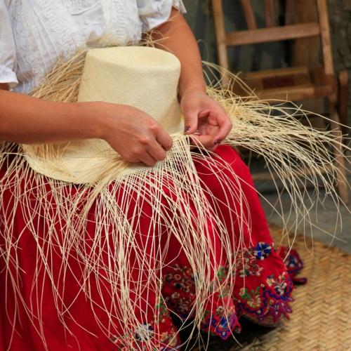 Een ambachtsvrouw maakt een Panama hoed