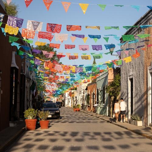 Straatje met kleurrijke papel picado vlaggen, Valladolid