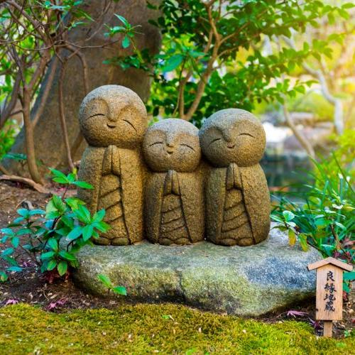 Glimlachend stenen beeldje van een boeddhistische monnik (Nagomi Jizo)